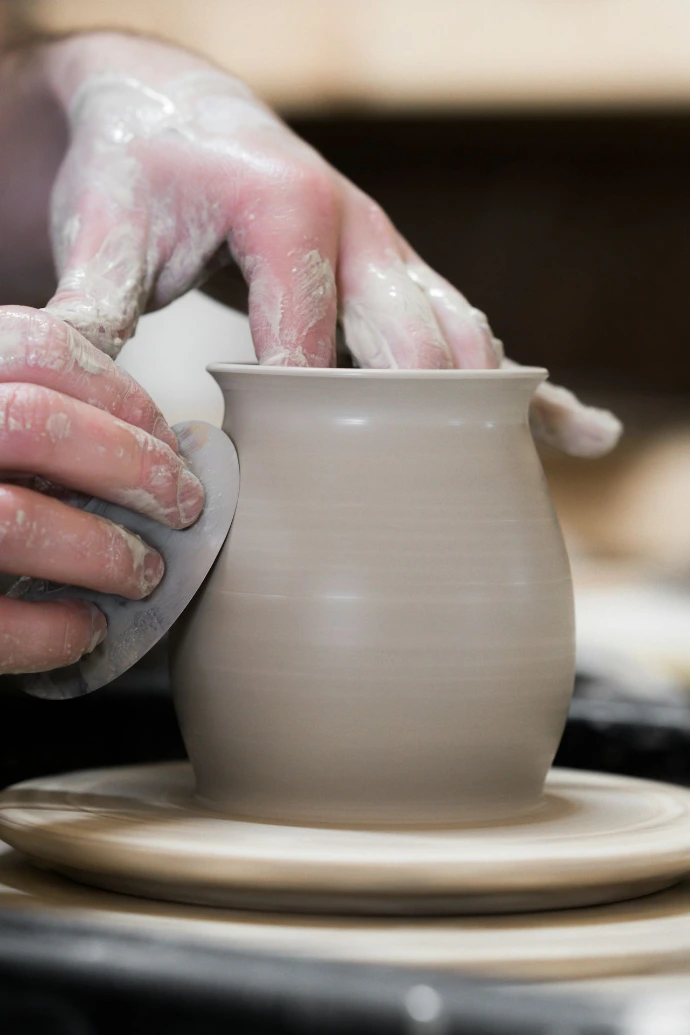 person holding white clay pot